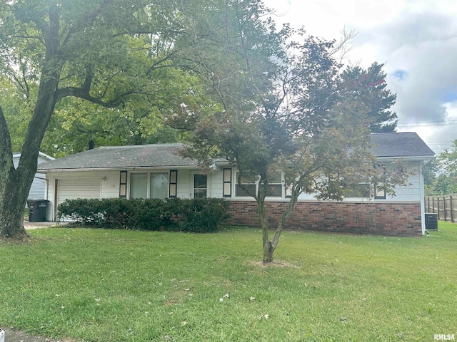 view of front of house with cooling unit, a garage, and a front yard