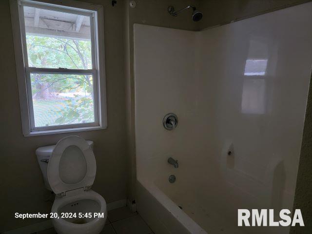 bathroom featuring tile patterned flooring, shower / bath combination, and toilet