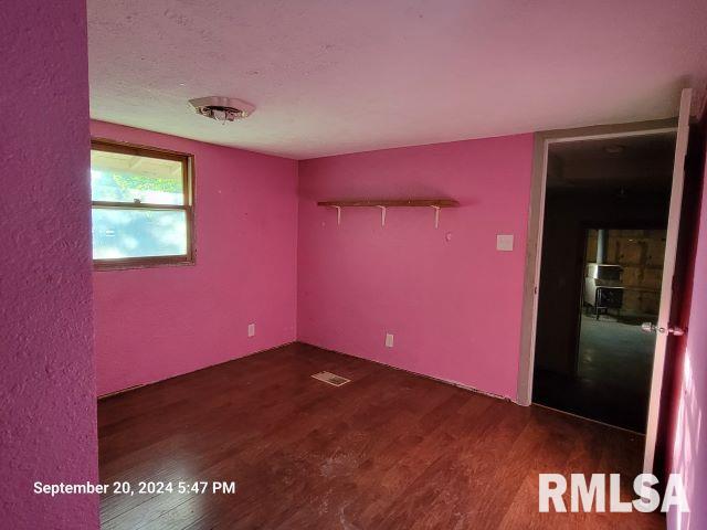 unfurnished room with dark hardwood / wood-style floors