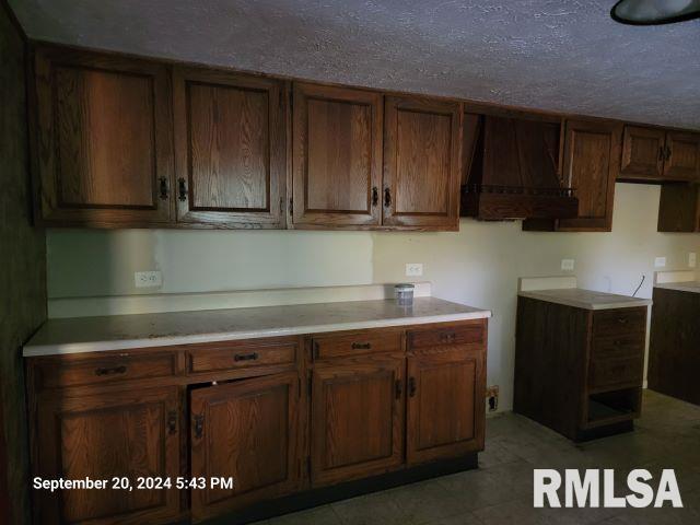 kitchen featuring a textured ceiling and premium range hood