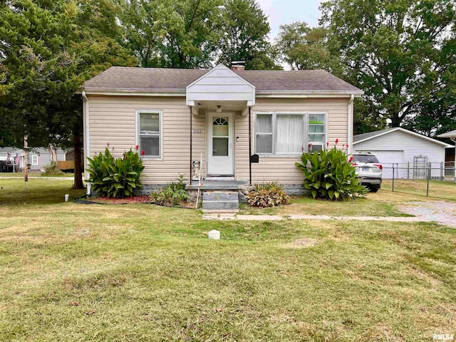 bungalow featuring a front yard, an outbuilding, and a garage