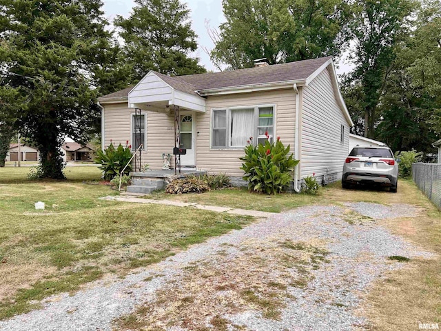 1106 N 11th St, Murphysboro, IL 62966 - bungalow-style house featuring driveway, a chimney, fence, a front lawn, and a shingled roof