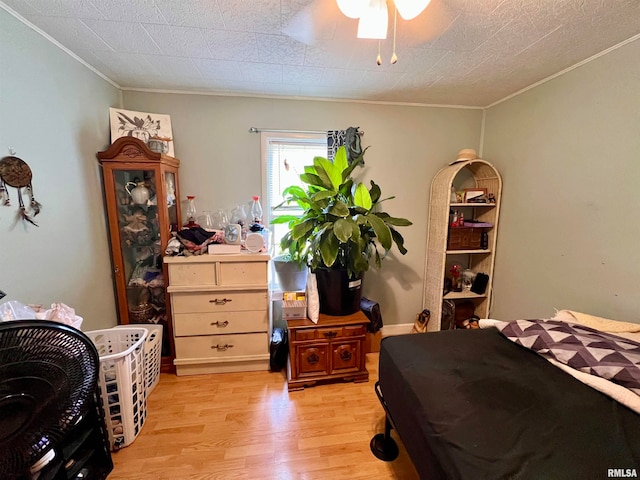 bedroom with light hardwood / wood-style flooring, ceiling fan, and crown molding