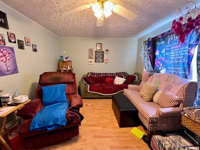 living room featuring ceiling fan, a textured ceiling, and light wood-type flooring