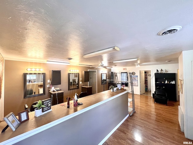 1106 N 11th St, Murphysboro, IL 62966 - kitchen featuring visible vents, wood finished floors, a breakfast bar area, and a textured ceiling