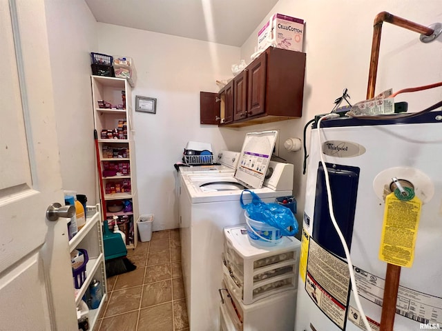 washroom featuring water heater, washing machine and dryer, tile patterned flooring, and cabinets