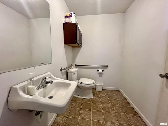 1106 N 11th St, Murphysboro, IL 62966 - bathroom with baseboards, toilet, and a sink