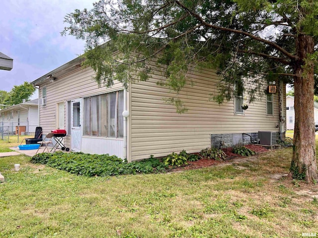 view of side of property with a lawn, cooling unit, and a patio area