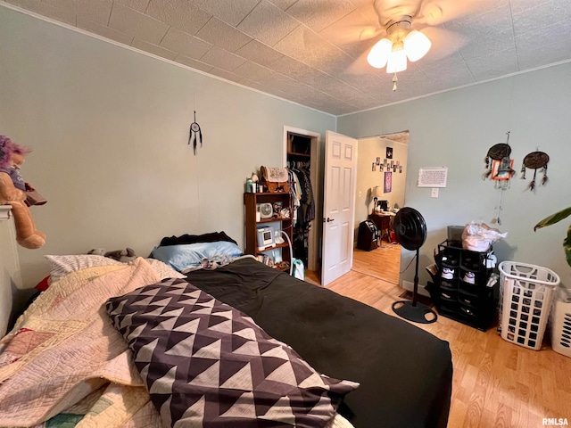 bedroom with a closet, light wood-type flooring, and ceiling fan