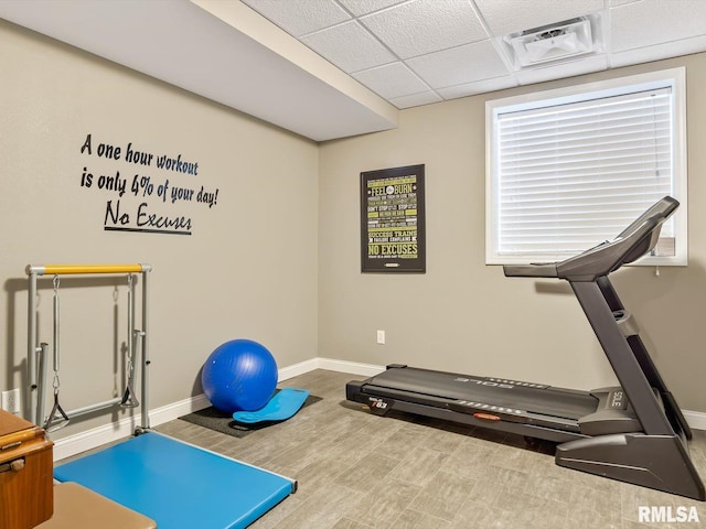 exercise area featuring a drop ceiling and hardwood / wood-style flooring