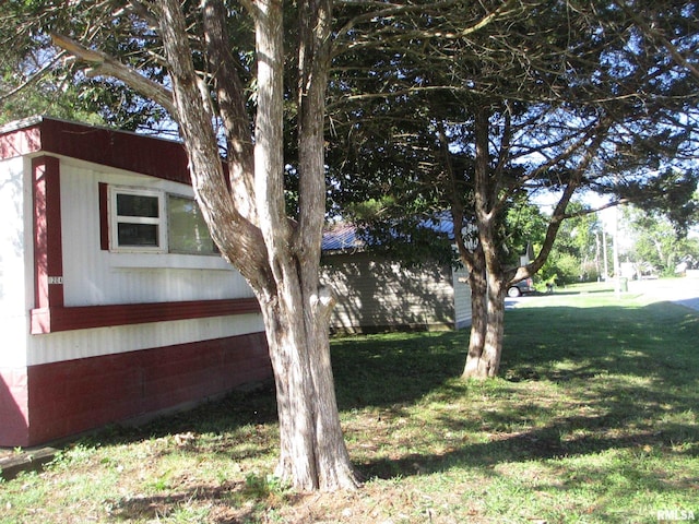 view of side of home with a yard