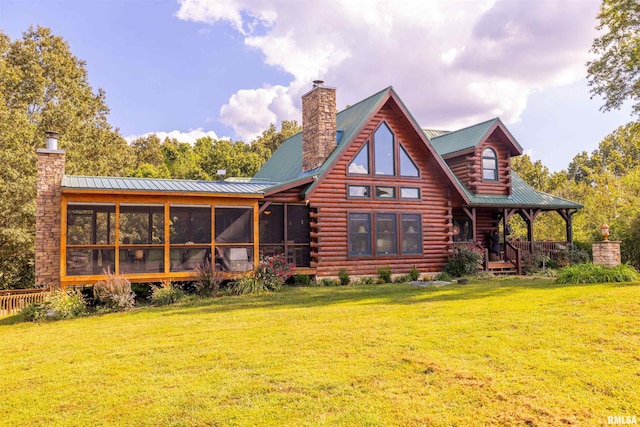 rear view of house with log exterior, a sunroom, and a chimney