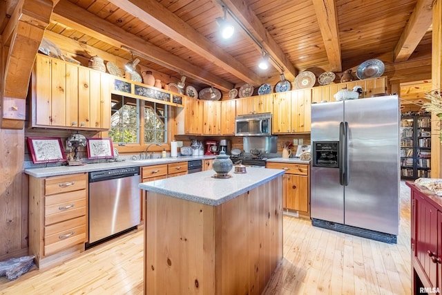 kitchen with beam ceiling, a sink, appliances with stainless steel finishes, wooden ceiling, and light wood finished floors