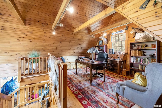 living area with wooden walls, lofted ceiling with beams, track lighting, wood-type flooring, and wooden ceiling