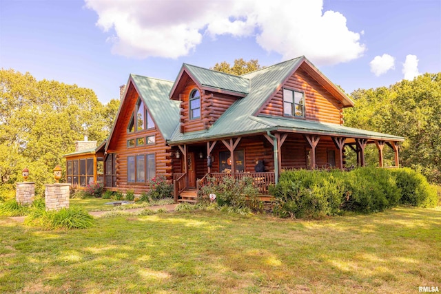 cabin featuring a front lawn, a sunroom, and covered porch