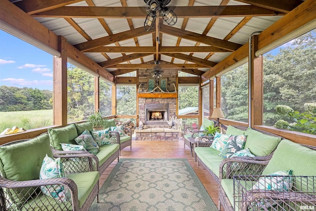 sunroom with a wealth of natural light, lofted ceiling with beams, and a ceiling fan