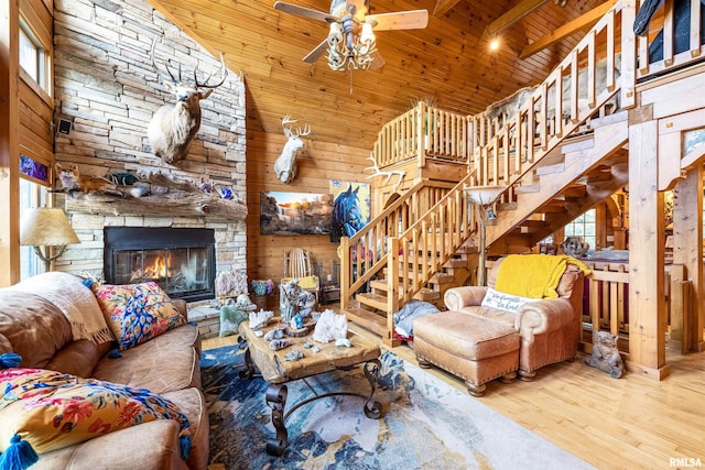 living room featuring wood ceiling, stairs, a fireplace, wood finished floors, and high vaulted ceiling