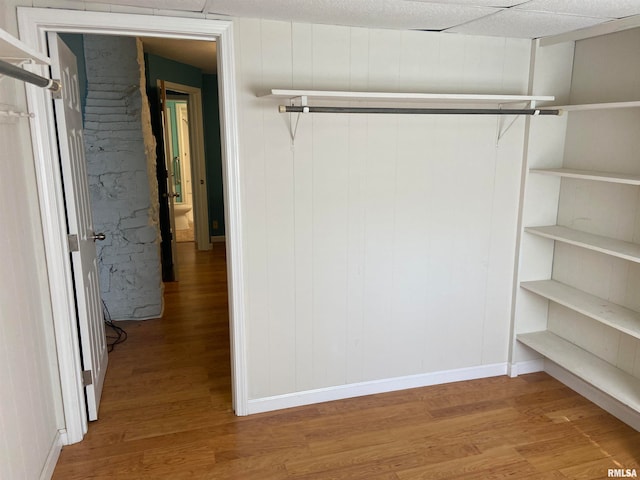 interior space with a paneled ceiling and hardwood / wood-style floors