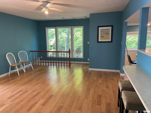 unfurnished room with ceiling fan, a textured ceiling, and light hardwood / wood-style flooring