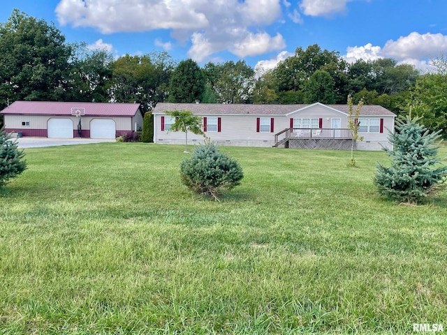 manufactured / mobile home featuring a front yard, a garage, and an outbuilding