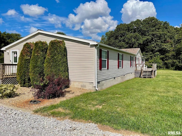 view of side of property with a wooden deck and a yard