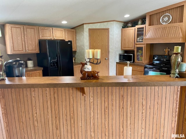 kitchen featuring premium range hood, crown molding, and black appliances