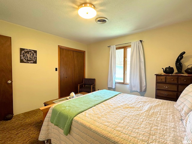 bedroom with carpet floors, a textured ceiling, and a closet