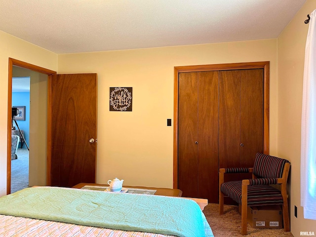 carpeted bedroom with a closet and a textured ceiling