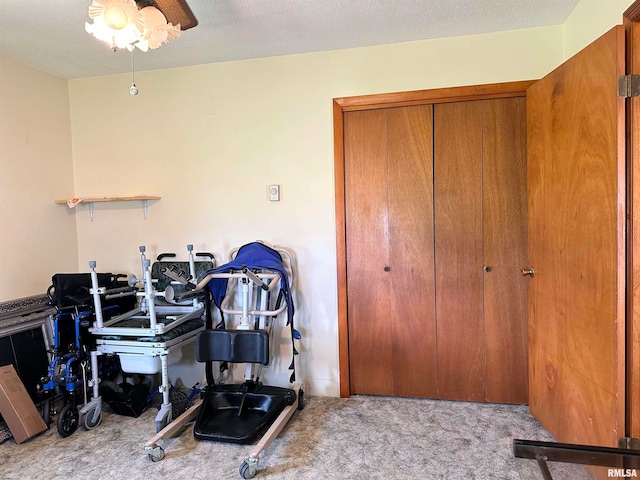 misc room featuring light carpet, a textured ceiling, and ceiling fan