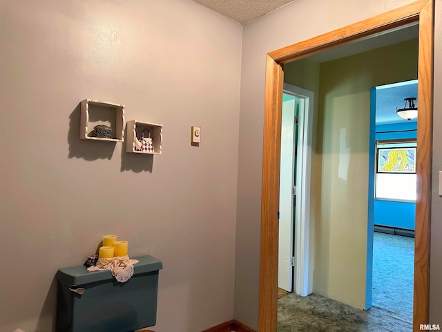 corridor featuring a textured ceiling and carpet flooring