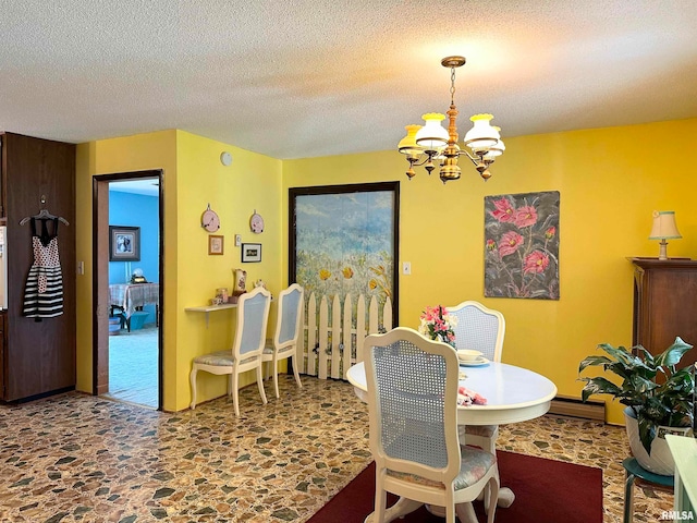 dining space with a notable chandelier and a textured ceiling