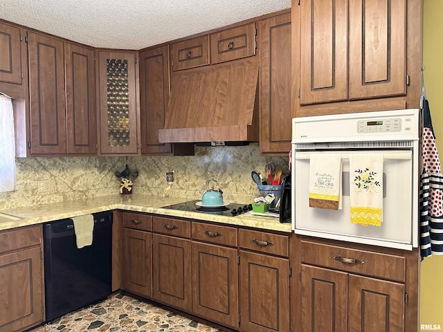 kitchen with custom exhaust hood, backsplash, a textured ceiling, and black appliances