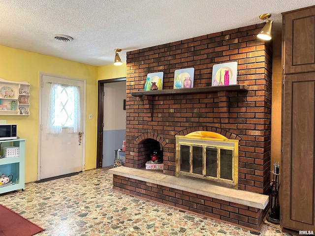 living room with a textured ceiling and a fireplace