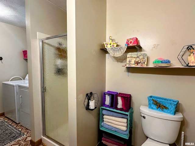 bathroom featuring a textured ceiling, independent washer and dryer, toilet, and an enclosed shower