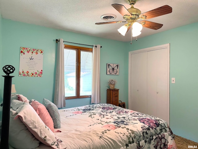 bedroom featuring a closet, ceiling fan, carpet flooring, and a textured ceiling