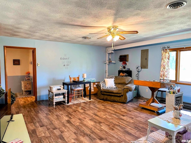 living room featuring electric panel, ceiling fan, hardwood / wood-style flooring, and a textured ceiling