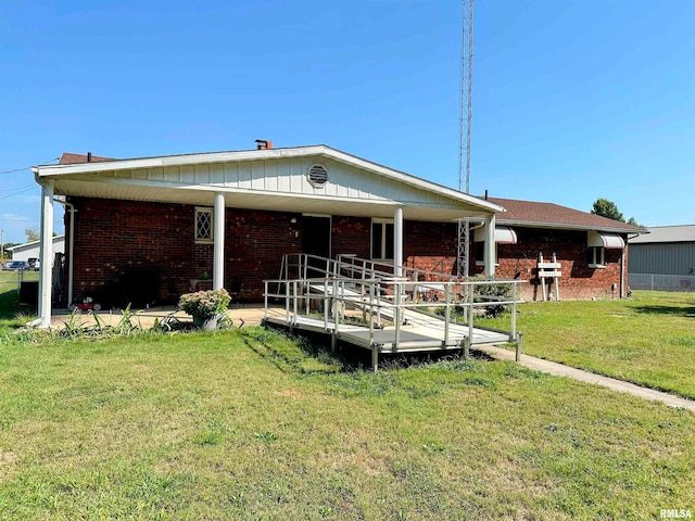 view of front of home featuring a front lawn, a wooden deck, and a patio area