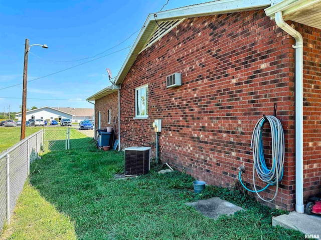 view of home's exterior with a yard and central AC