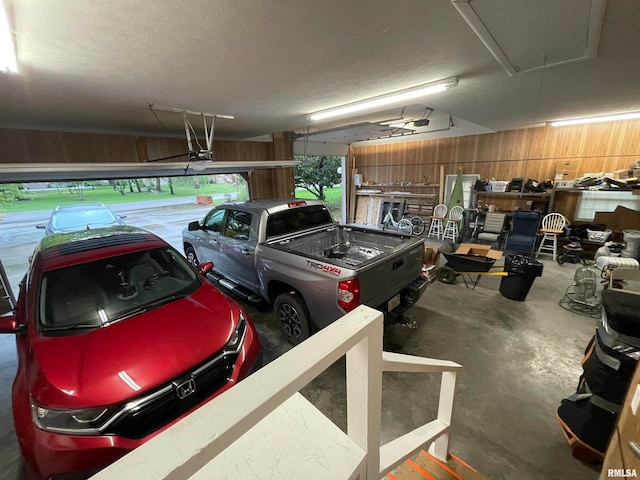 garage featuring a garage door opener and wood walls