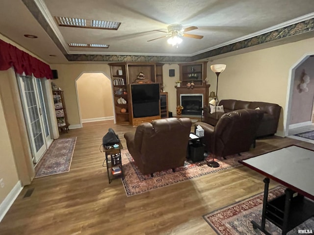 living room with crown molding, ceiling fan, and wood-type flooring