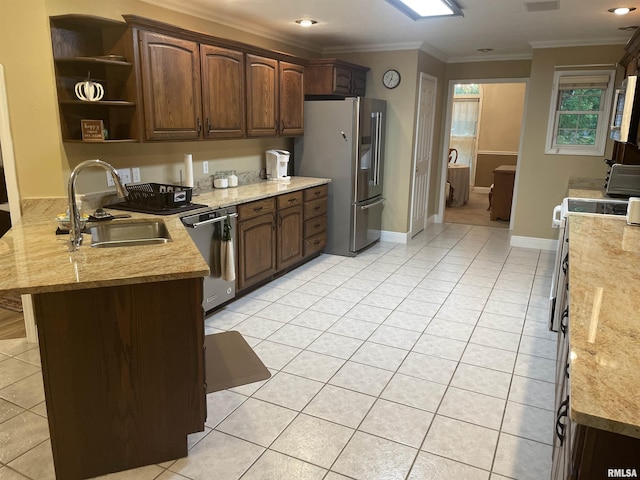 kitchen featuring light tile patterned floors, a peninsula, ornamental molding, a sink, and stainless steel appliances