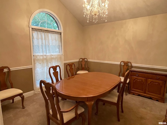 carpeted dining area with lofted ceiling and a notable chandelier