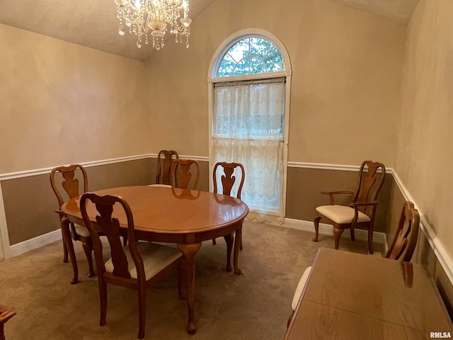 carpeted dining area featuring a notable chandelier, vaulted ceiling, and a textured ceiling