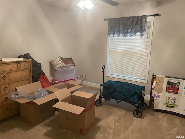 interior space with ceiling fan and light colored carpet