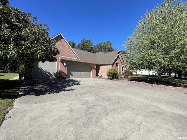 view of front of property featuring brick siding, a garage, and concrete driveway