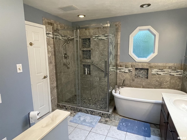 full bathroom with a soaking tub, a stall shower, vanity, a wainscoted wall, and tile patterned floors