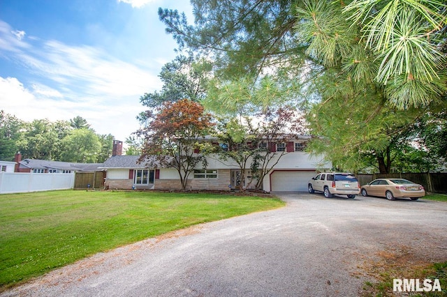 view of front of home with a front yard and a garage