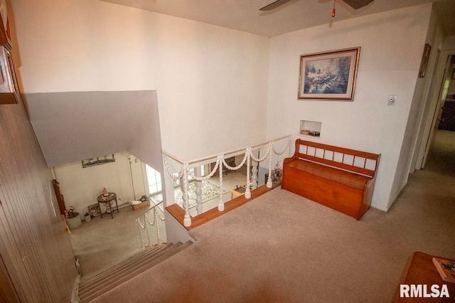 staircase with ceiling fan and carpet flooring