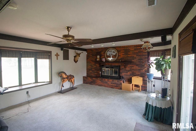 carpeted living room with a brick fireplace, beam ceiling, and ceiling fan