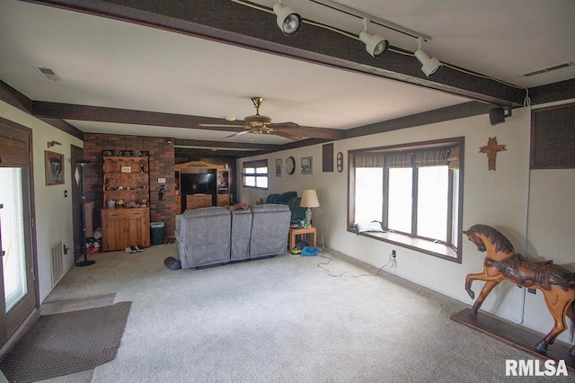 living room featuring ceiling fan, beamed ceiling, carpet flooring, and rail lighting